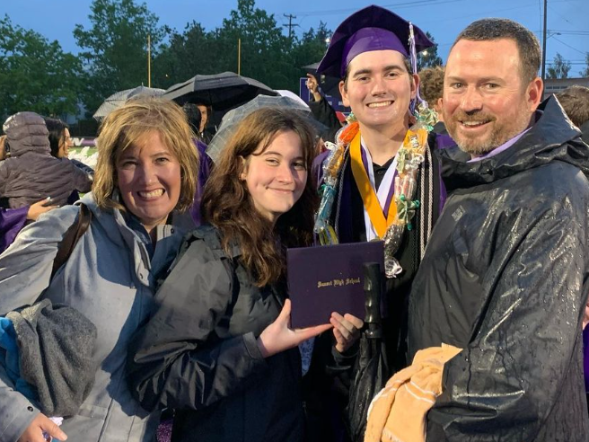 This is a photo of Peter's Awesome Family at his rainy HS graduation